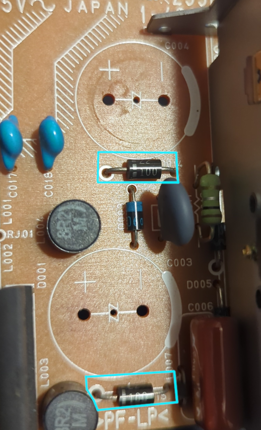 Photo showing the PSU with the capacitors removed. The TVS diodes are outlined in cyan.