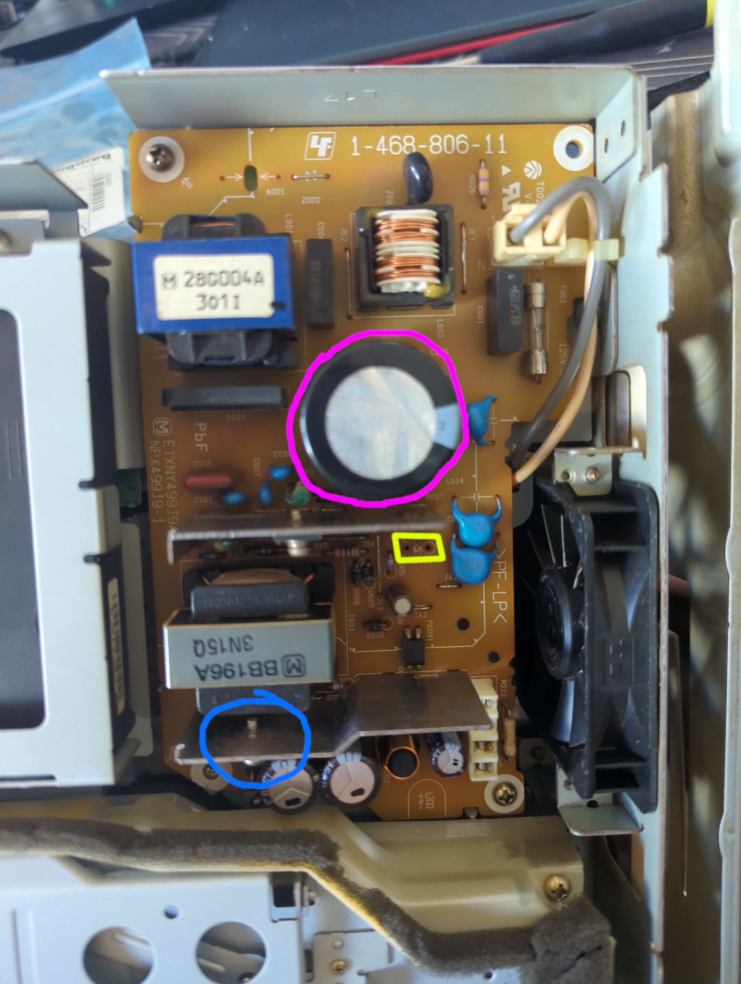 Photo highlighting a big cylinder in the middle of the board in magenta, a smaller pair of holes with a diode symbol in yellow, and a section of a heatsink with a screw running through it in blue.